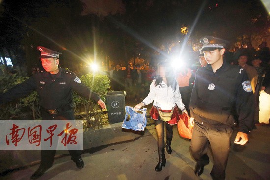 一名浓妆艳抹的擦鞋女被警方带走调查。 记者苏华摄